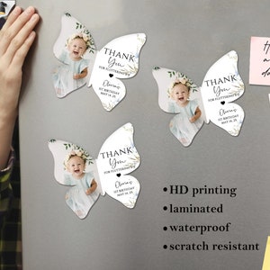 May include: Butterfly-shaped magnets featuring a baby girl's photo, floral details, and the text "THANK YOU FOR FLUTTERING BY! Olivia's 1st Birthday MAY 14, 25." These magnets are laminated, waterproof, and scratch resistant.