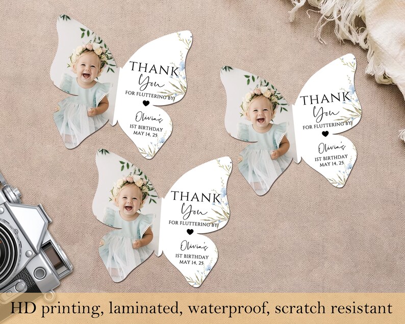 May include: Butterfly-shaped thank you cards with a baby's photo, floral details, and the text "Thank You for Fluttering By." The cards also include the text "Olivia's 1st Birthday May 14, 25." The cards are laminated and scratch resistant.
