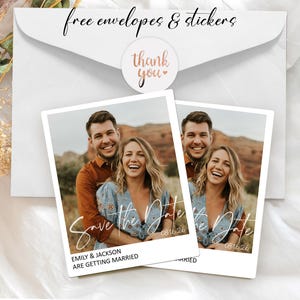 May include: Two photo cards with a couple smiling, with the text "Save the Date" and the date 08.16.26. The cards are on a white background with a white envelope and a "thank you" sticker. The text "free envelopes & stickers" is written above.
