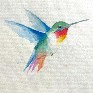 May include: Watercolor painting of a hummingbird in flight. The bird features a green head, red throat, and a mix of blue, green, orange, and purple on its wings and body. The background is a textured white.