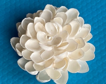 Delicate layers of white shells create a stunning floral replica event enchantment home decor wedding and other event decor and centerpiece.