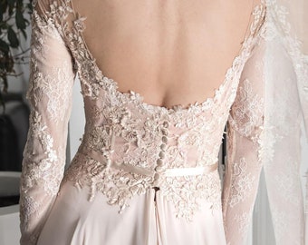 Könnte beinhalten: Ein weißes Spitzen-Hochzeitskleid mit tiefem Rücken und langen Ärmeln. Das Kleid hat ein figurbetontes Oberteil und einen fließenden Rock.