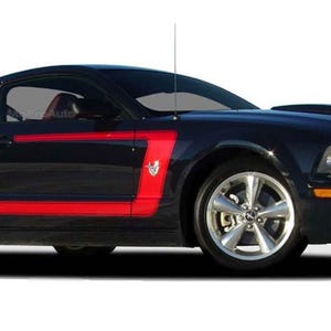 May include: A black Ford Mustang with red racing stripes. The car has a black hood scoop and a black grille with a chrome Ford emblem.