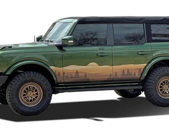 May include: A green Ford Bronco with a black soft top and a mountain scene decal on the side. The vehicle has bronze-colored wheels and a black front bumper.