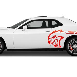May include: A white Dodge Challenger SRT with red accents and a red and black Dodge logo on the side.