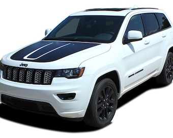May include: A white Jeep Cherokee with black accents on the hood, side, and wheels. The Jeep has a black grille with a chrome Jeep logo.