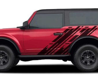 May include: A red Ford Bronco with black accents and a black and red graphic decal on the side. The vehicle is a two-door model with a black roof and black wheels.