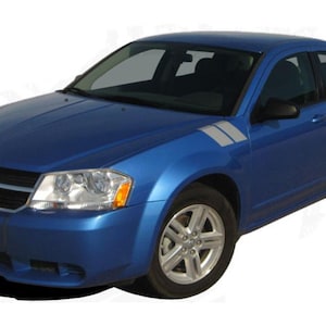 Op de afbeelding: Een blauwe Dodge Avenger met zilveren accentstrepen op de spatborden. De auto staat geparkeerd op een witte achtergrond.