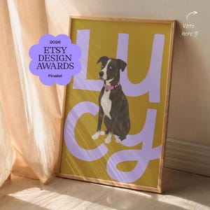 May include: A framed wall art print featuring a dark brown and white dog wearing a pink collar, centred against a mustard yellow background with the large light purple letters spelling LUCY. A purple badge reads 2026 ETSY DESIGN AWARDS Finalist.