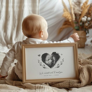 Op de afbeelding: Een ingelijst zwart-wit echografiebeeld van een baby in de vorm van een hart met de tekst "We cannot wait to meet you" en de datum "January 2024 | 17 weeks".