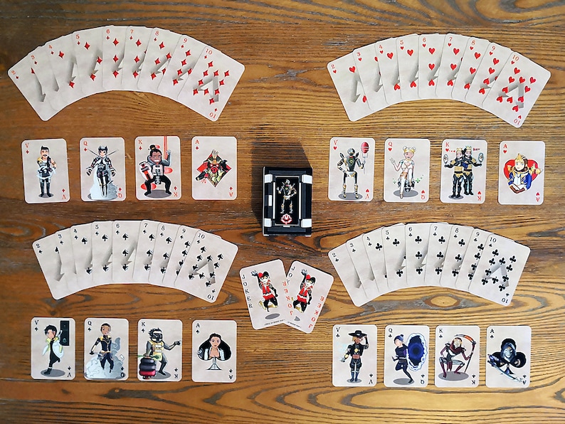 May include: A deck of playing cards with illustrated characters on the face cards. The cards are arranged in a fan shape, with the suits of hearts, diamonds, clubs, and spades visible. There are two Jokers in the center of the image.