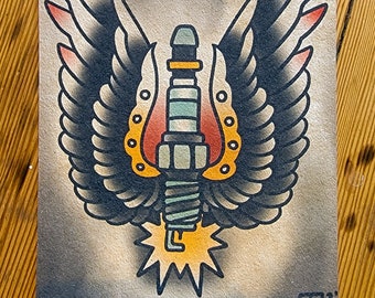 May include: A traditional tattoo style illustration of a spark plug with wings. The spark plug is surrounded by a horseshoe and has a yellow flame coming from the bottom. The wings are black with red accents.