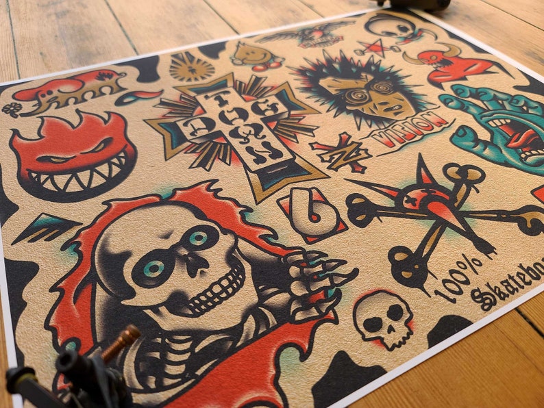 May include: A tan poster with tattoo-style illustrations. Designs include a flaming skull, a cross, a hand, and the text "100% Skateboards". The artwork is in red, black, blue, and gold.