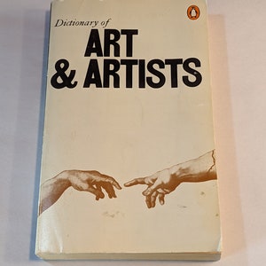 Puede incluir: Un libro de bolsillo Penguin vintage titulado "Dictionary of Art & Artists" con una ilustración marrón de dos manos que se alcanzan.