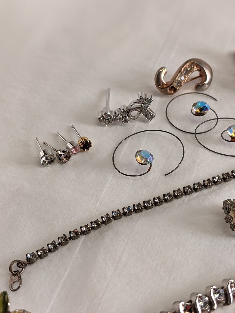 May include: Assortment of jewellery pieces including a silver and crystal earring, a silver and crystal pendant, a silver and crystal bracelet, and a silver and crystal ring.