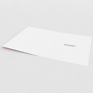 May include: A white greeting card with the text "Your Personalised Message Here!" printed in black. The card has a red edge and is slightly angled, suggesting it's open or partially folded.