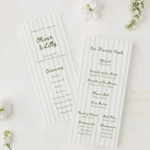 Pode incluir: Dois programas de cerimónia de casamento com design de riscas verdes e texto. Os programas listam os nomes do casal, os detalhes da cerimónia e os convidados. Flores brancas estão espalhadas pelos programas.