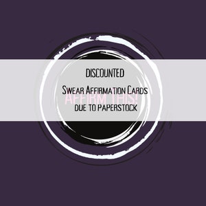 May include: A white banner with black text that reads "DISCOUNTED" "SWEAR AFFIRMATION CARDS" "AFFIRM THIS!" "DUE TO PAPERSTOCK" on a purple background with a black and white circle graphic.