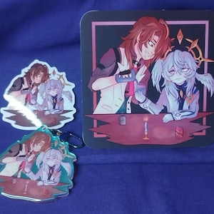 May include: Two anime characters, one with brown hair and one with white hair, are sitting at a table with a lit candle. The characters are holding small cups. The image is printed on a white sticker and a clear acrylic keychain.