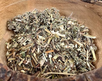 May include: A wooden bowl filled with dried herbs and plant material. The bowl is made of natural wood and has a rustic appearance.