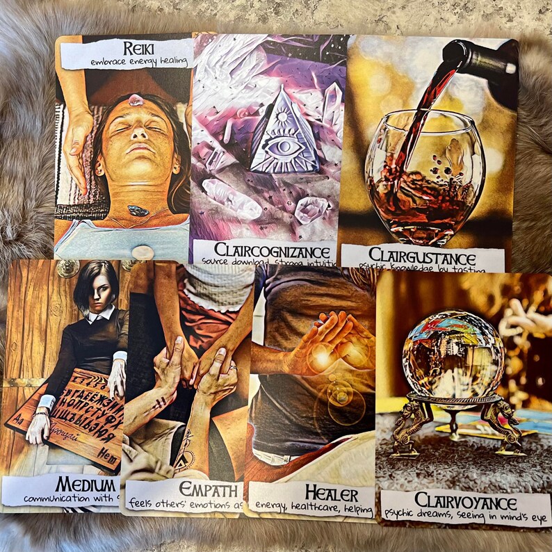 May include: A set of ten tarot cards with colorful illustrations and text. The cards are arranged in two rows of five. The top row features cards titled "Reiki", "Claircognizance", "Clairgustance", "Empath", and "Healer". The bottom row features cards titled "Medium", "Clairvoyance", "The World", "The Sun", and "The Moon".