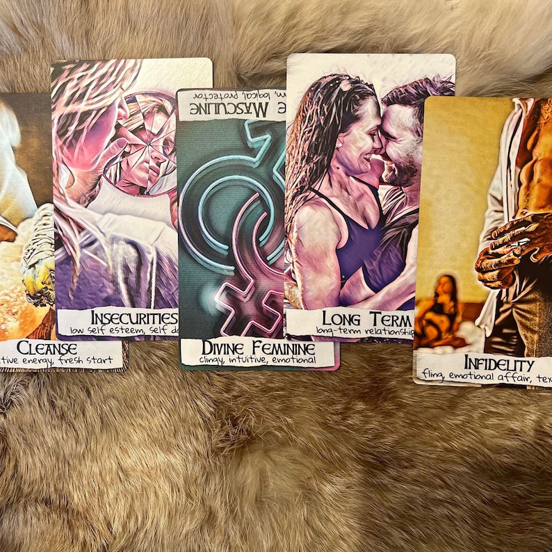 May include: Five tarot cards with colorful illustrations and handwritten text. The cards are laid out on a brown furry surface. The text on the cards reads: "Insecurities, low self esteem, self doubt", "Cleanse, the energy, fresh start", "Divine Feminine, clingy, intuitive, emotional", "Long Term, long-term relationship", "Infidelity, fling, emotional affair, text".