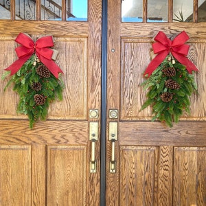 Décoration de Noël Artificielle. Rouge ou marron. Couronne d'hiver en pin avec cloches, pommes de pin et baies. Couronne de porte double vraie touche