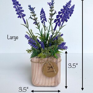 K&ouml;nnte beinhalten: Eine gro&szlig;e k&uuml;nstliche Lavendelpflanze in einem quadratischen Holztopf mit einer Gr&ouml;&szlig;e von 8,9 cm mit einem handgefertigten Etikett. Die Pflanze ist 25,4 cm hoch.