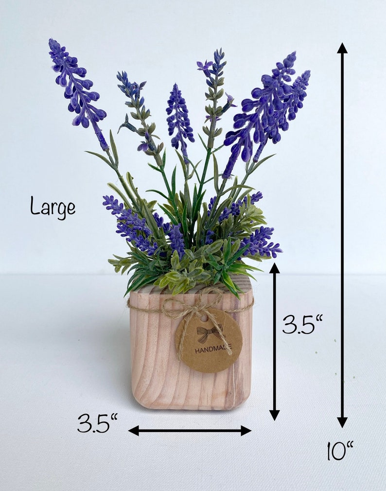 K&ouml;nnte beinhalten: Eine gro&szlig;e k&uuml;nstliche Lavendelpflanze in einem quadratischen Holztopf mit einer Gr&ouml;&szlig;e von 8,9 cm mit einem handgefertigten Etikett. Die Pflanze ist 25,4 cm hoch.