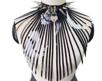 Op de afbeelding: Een zwarte leren choker met zilveren spikes en een zilveren hartvormige hanger. De ketting is op een mannequinbuste.