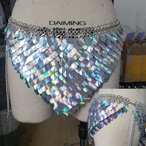 Op de afbeelding: Een zilveren kettinghemd body chain met iriserende schubben. Het kettinghemd heeft een V-vorm en heeft een DAIMING label aan de bovenkant.