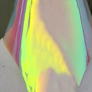 May include: A sheet of iridescent holographic vinyl with a rainbow of colors, including pink, green, yellow, and blue.