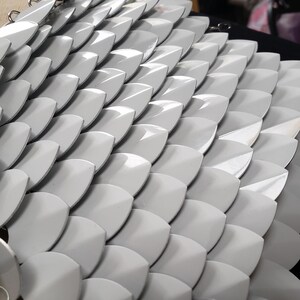 Peut inclure: Gros plan sur une armure de chainmail argentée avec une finition brillante. La cotte de mailles est faite de petites écailles métalliques qui se chevauchent.
