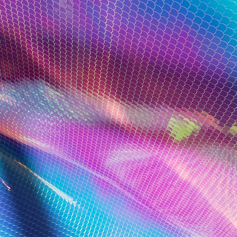 May include: A close-up of iridescent fabric with a scale-like pattern. The fabric is a gradient of blue, purple, and pink.