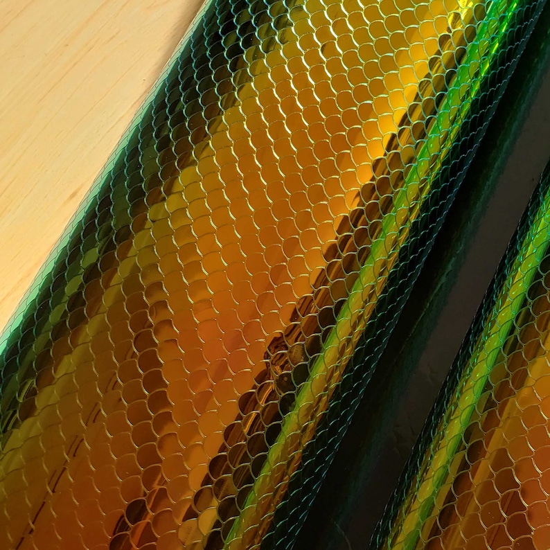 May include: Two rolls of iridescent green and gold vinyl with a snake skin pattern.