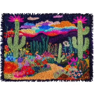 Op de afbeelding: Handgehaakte vloerkleed met een woestijnlandschap met cactussen, bloemen en een kleurrijke zonsondergang. Het vloerkleed heeft een donkerblauwe achtergrond met groene cactussen, rode, roze en gele bloemen en een levendige zonsondergang.