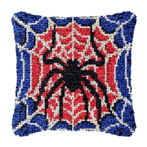 May include: Square decorative pillow featuring a black spider design on a red and white web, framed by a blue border. The pillow has a textured, tufted appearance, adding depth to the design. A unique accent piece for any room.