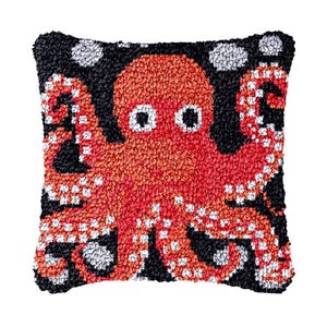 Puede incluir: Una almohada de pulpo roja y blanca con detalles negros. El pulpo está sobre un fondo negro con lunares blancos.