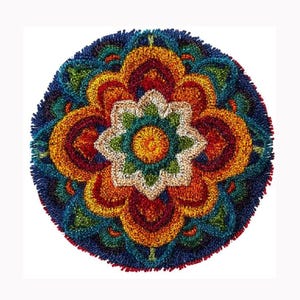 May include: A circular punch needle rug featuring a symmetrical floral mandala pattern. The design consists of concentric layers in vibrant shades of yellow, orange, red, green, and deep blue, with a textured, looped yarn pile surface throughout.