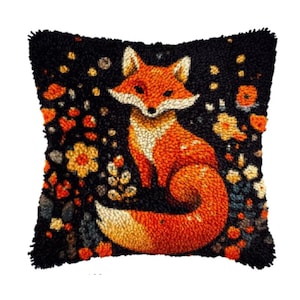 May include: A square, black decorative pillow featuring a vibrant orange fox with a white chest and face. The fox is surrounded by colorful flowers and foliage. The pillow has a textured, hand-stitched appearance, perfect for adding a touch of nature to any room.