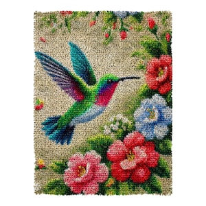 May include: A detailed rug featuring a vibrant hummingbird in flight, surrounded by colourful flowers. The bird has green, blue, and red plumage. The flowers are red, pink, and blue, set against a beige background.