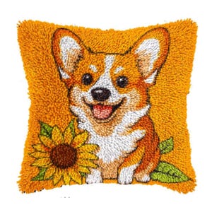 Può includere: Un cuscino quadrato arancione strutturato con un cane corgi sorridente con pelo marrone e bianco. Un girasole giallo con foglie verdi è accanto al cane. Il cuscino ha un aspetto fatto a mano e strutturato.
