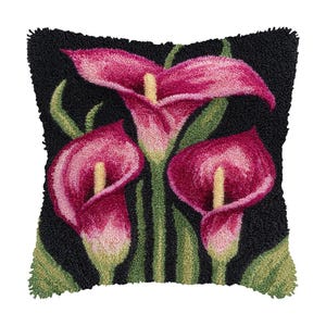 Peut inclure: Un coussin décoratif carré noir avec un motif floral. Le motif présente trois callas roses avec des centres jaunes et des tiges et feuilles vertes. Le coussin a un aspect texturé et touffeté.