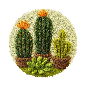 May include: A circular, textured wall hanging depicting three cacti in brown pots. The cacti are green with orange tops, set against a light beige background. A green succulent sits at the base.