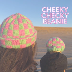 May include: Two people wearing pink and green checkered beanies. The text "CHEEKY CHECKY BEANIE" is written in pink letters on a light blue background.