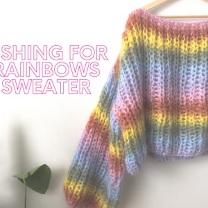 Könnte beinhalten: Ein regenbogenfarbener Strickpullover mit lockerer Passform und langen Ärmeln. Der Pullover ist im Cropped-Stil gehalten und hat einen lässigen, entspannten Look.