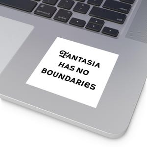 May include: A white square sticker with the text "FANTASIA HAS NO BOUNDARIES" in black, placed on a laptop. The sticker's text is in a stylized font.