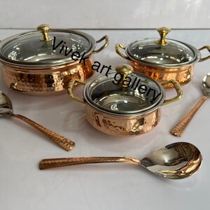 以下が含まれることがあります： ガラスの蓋と2本の銅製のサービングスプーンが付いた、銅製のサービングボウル3個セット。ボウルはハンマード仕上げで、ハンドルは金色。スプーンもハンマード仕上げです。