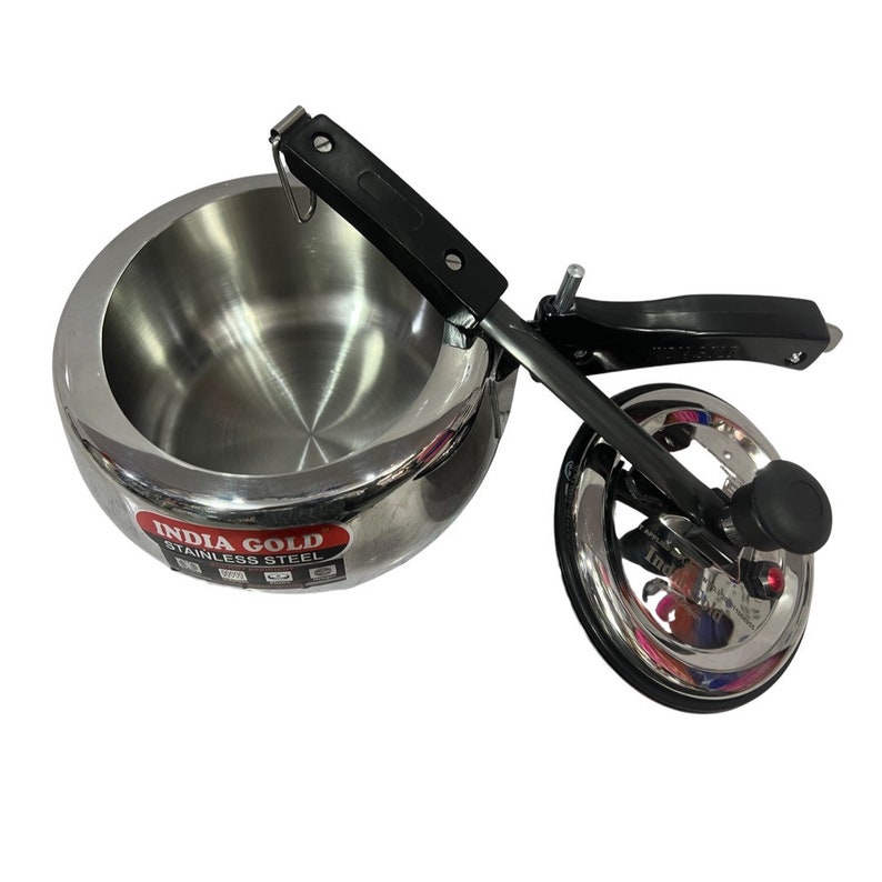 May include: A silver stainless steel pressure cooker with a black handle and a red and white label that says "India Gold Stainless Steel".