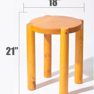 K&ouml;nnte beinhalten: Ein Hocker aus Holz mit runder Oberseite und vier Beinen. Der Hocker ist 46 cm breit und 53 cm hoch.